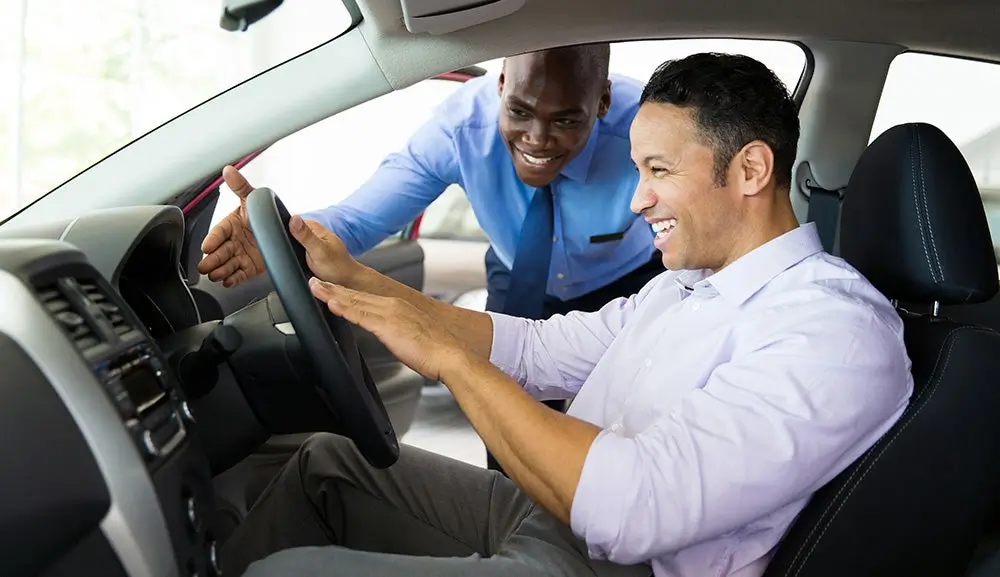 Driver behind the wheel on a test drive with both hands on the steering wheel
